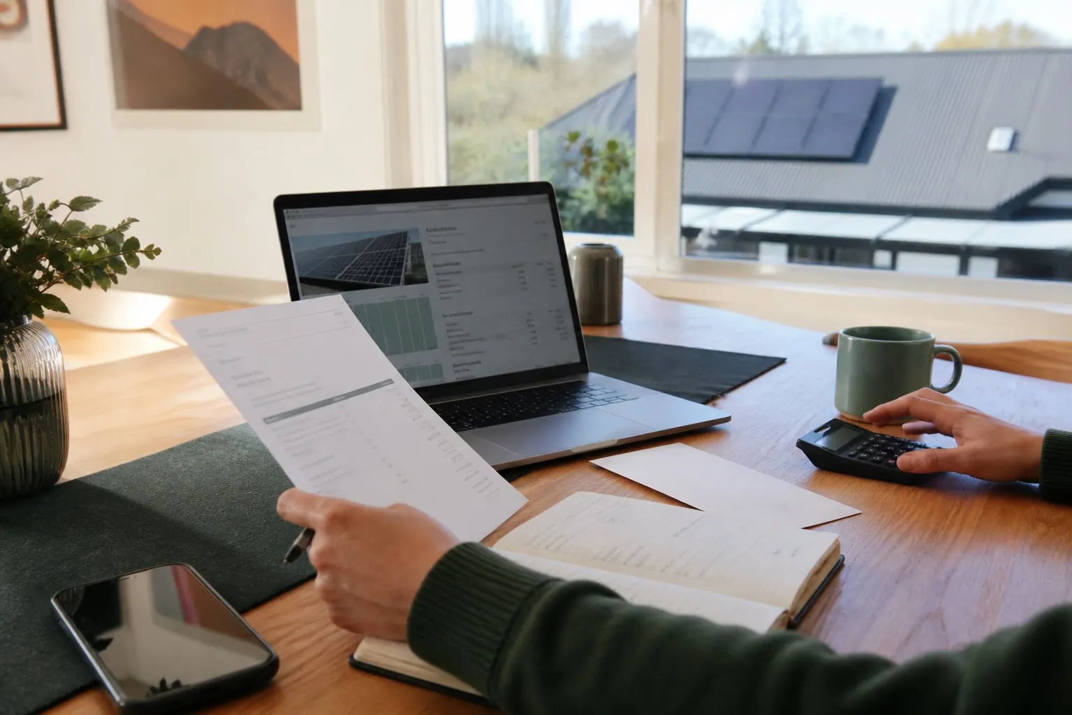 Homeowner reviewing solar quote and repayment paperwork at a Canterbury kitchen table