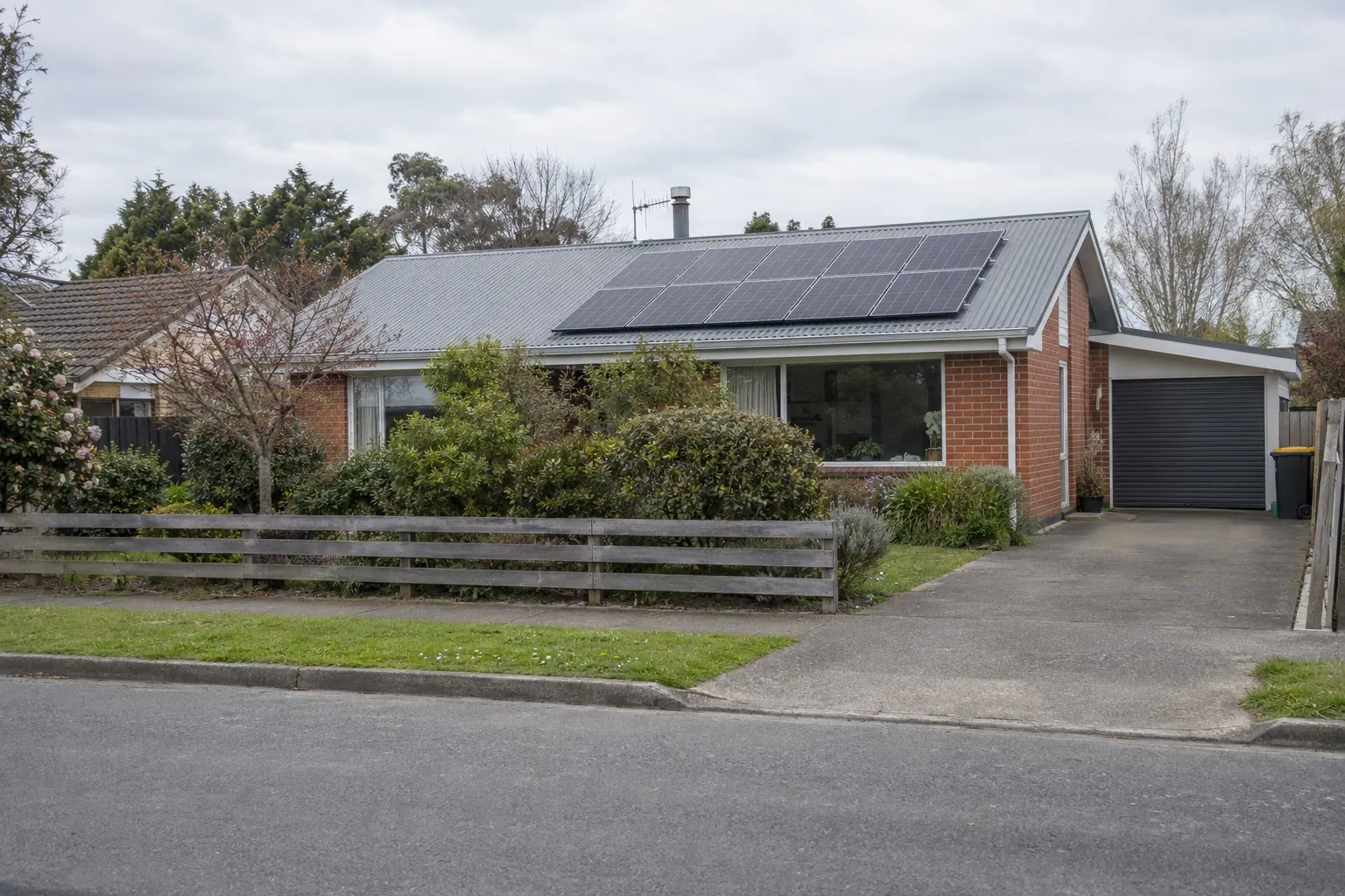 Solar panels on a brick home with an established garden